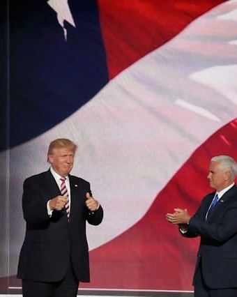 Trump on a scene with the american flag in back